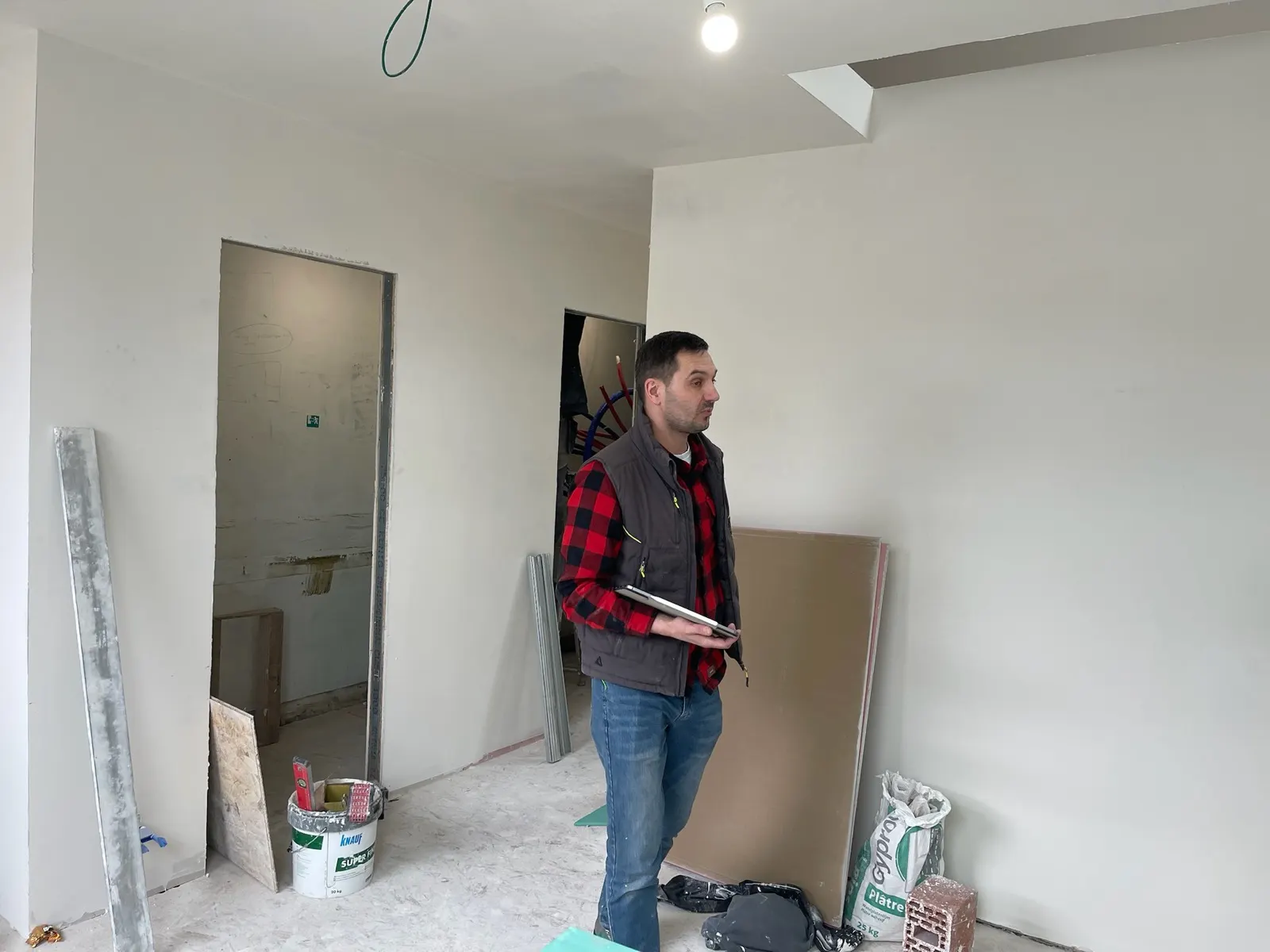 Membre de l'équipe sur un chantier de plafonnage, plaques et enduits prêts à poser