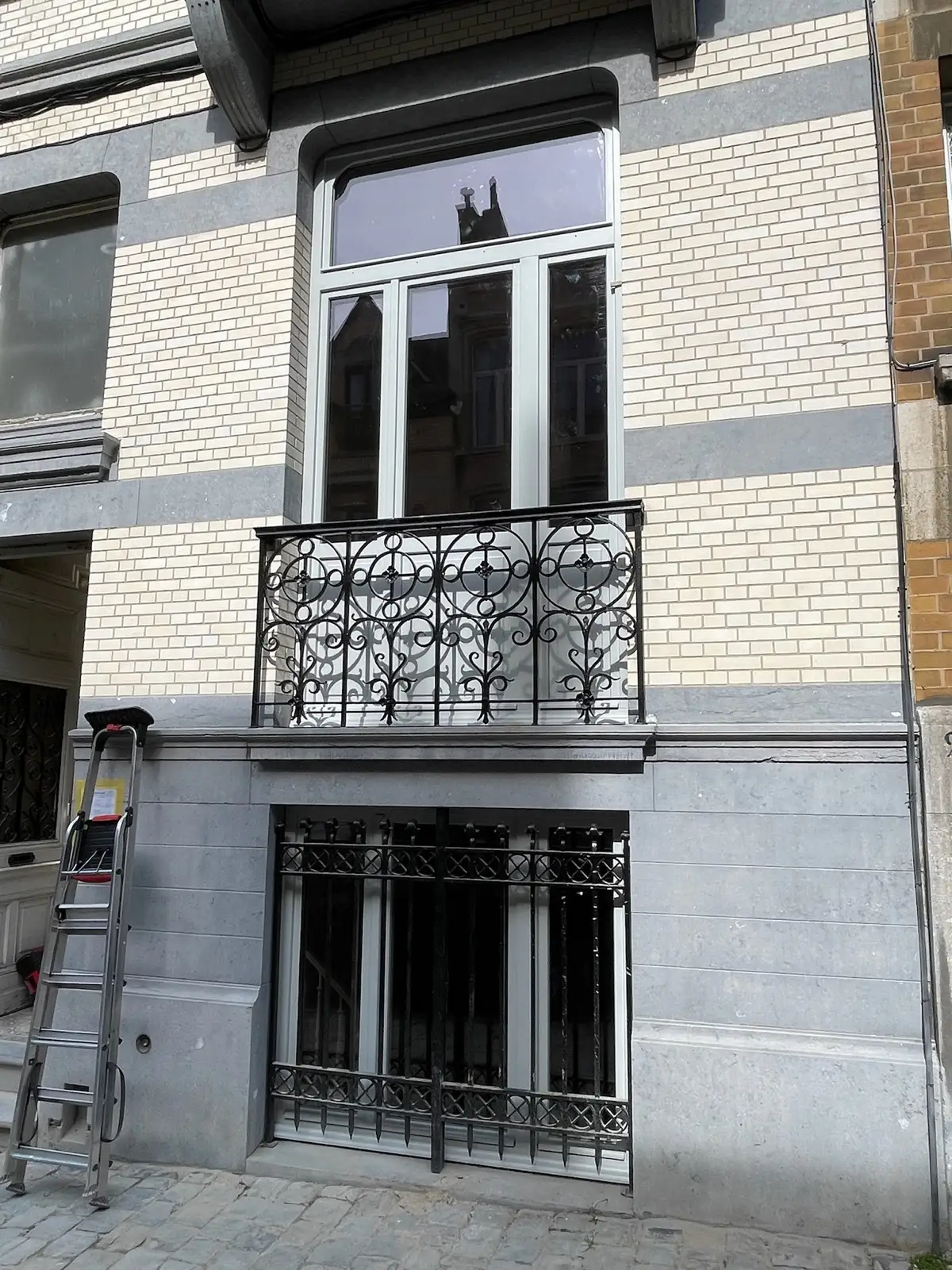 Façade restaurée, ferronneries repeintes en noir et soubassement en pierre bleue