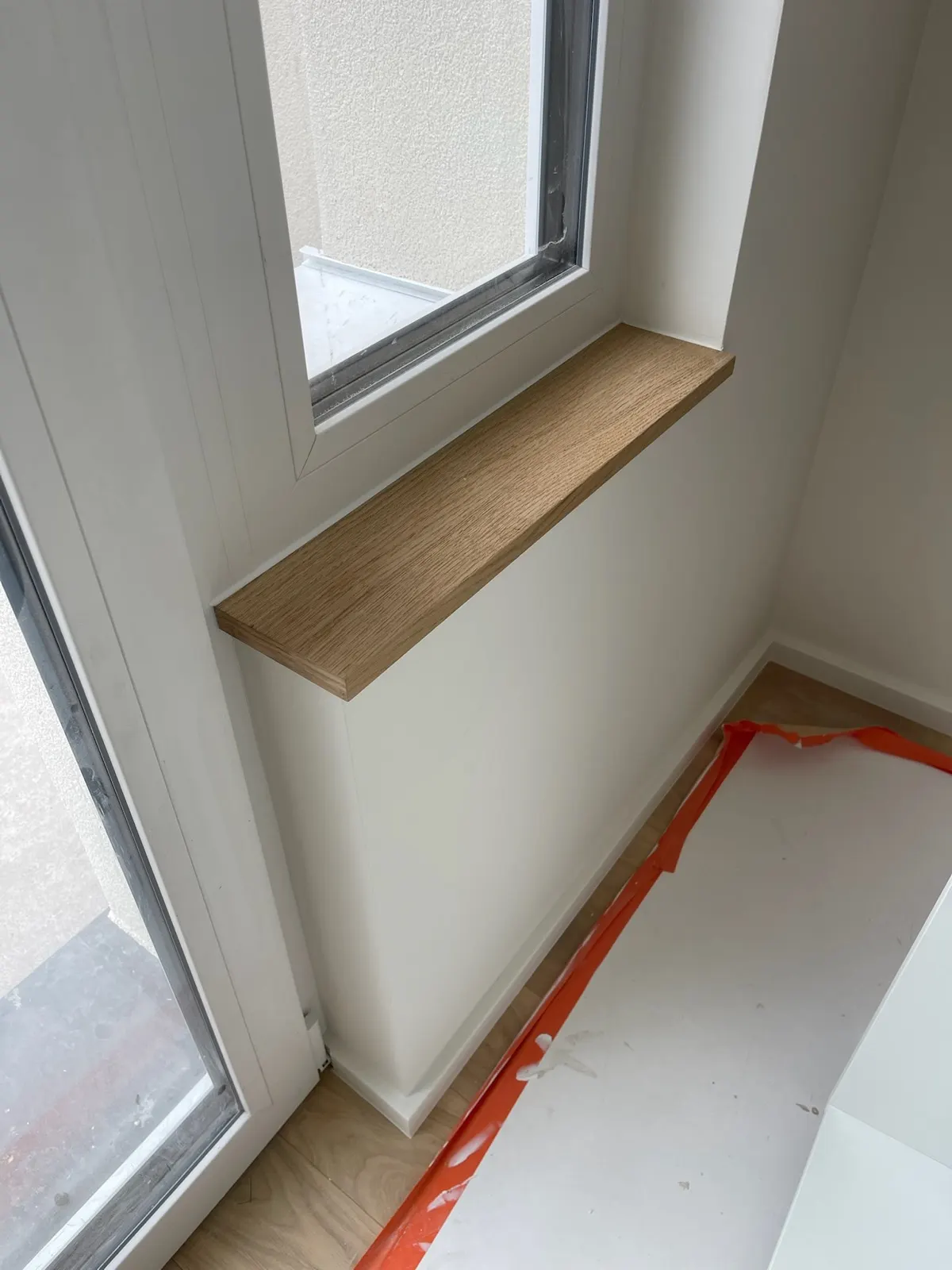 Châssis blanc et tablette de fenêtre en bois clair, mur fraîchement peint