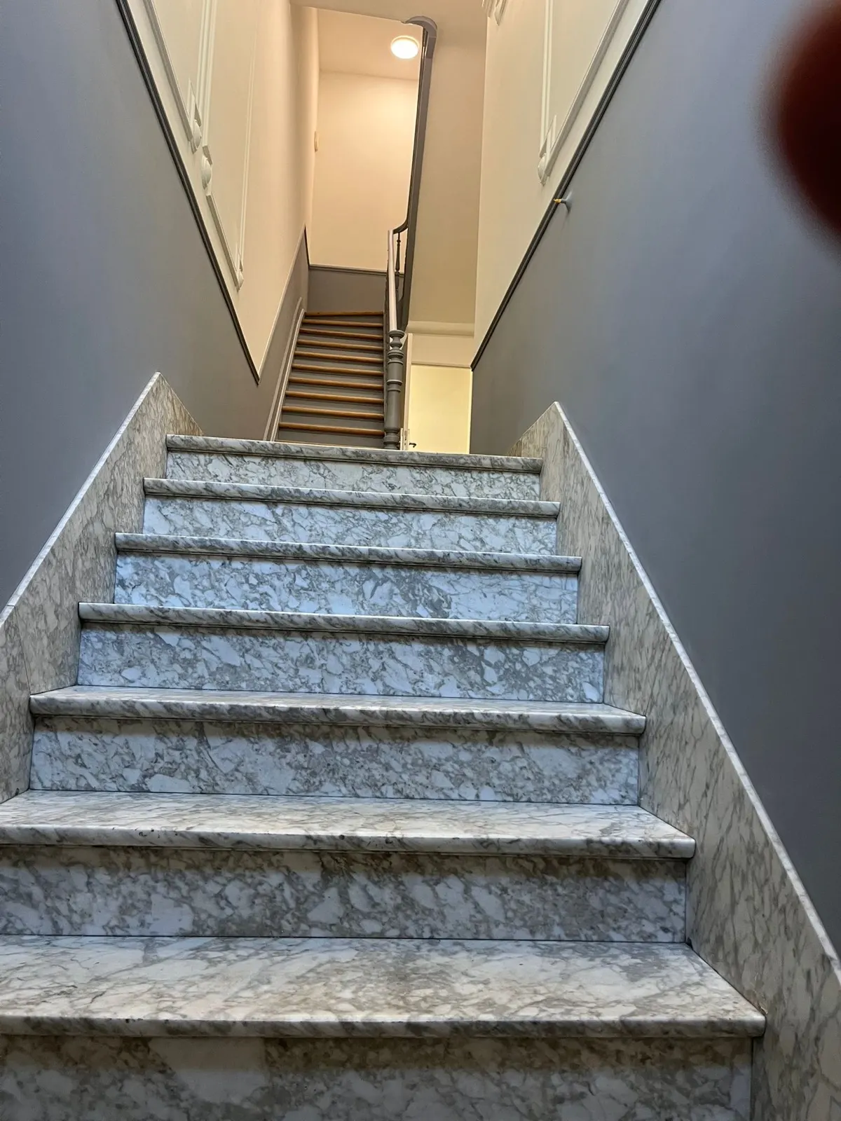 Escalier en marbre encadré de deux murs gris fraîchement peints