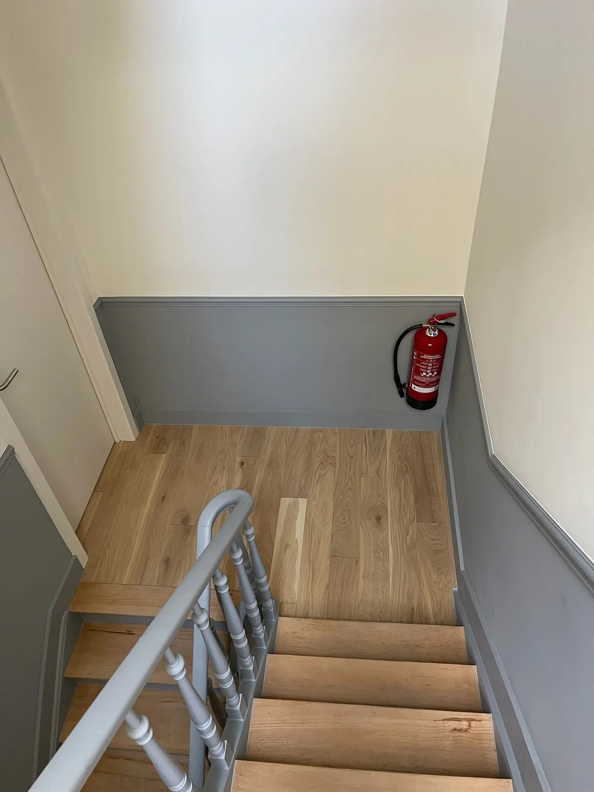 Palier repeint avec soubassement gris et parquet clair posé à neuf